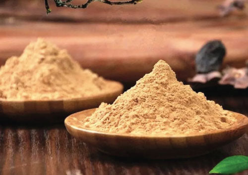Two wooden bowls filled with brown Sandalwood powder on a wooden surface.