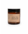 An amber glass jar candle with a black lid and a beige label reading 'COME ALIVE CO. ZEN TEA LOOSE LEAF BLEND' on a white background.