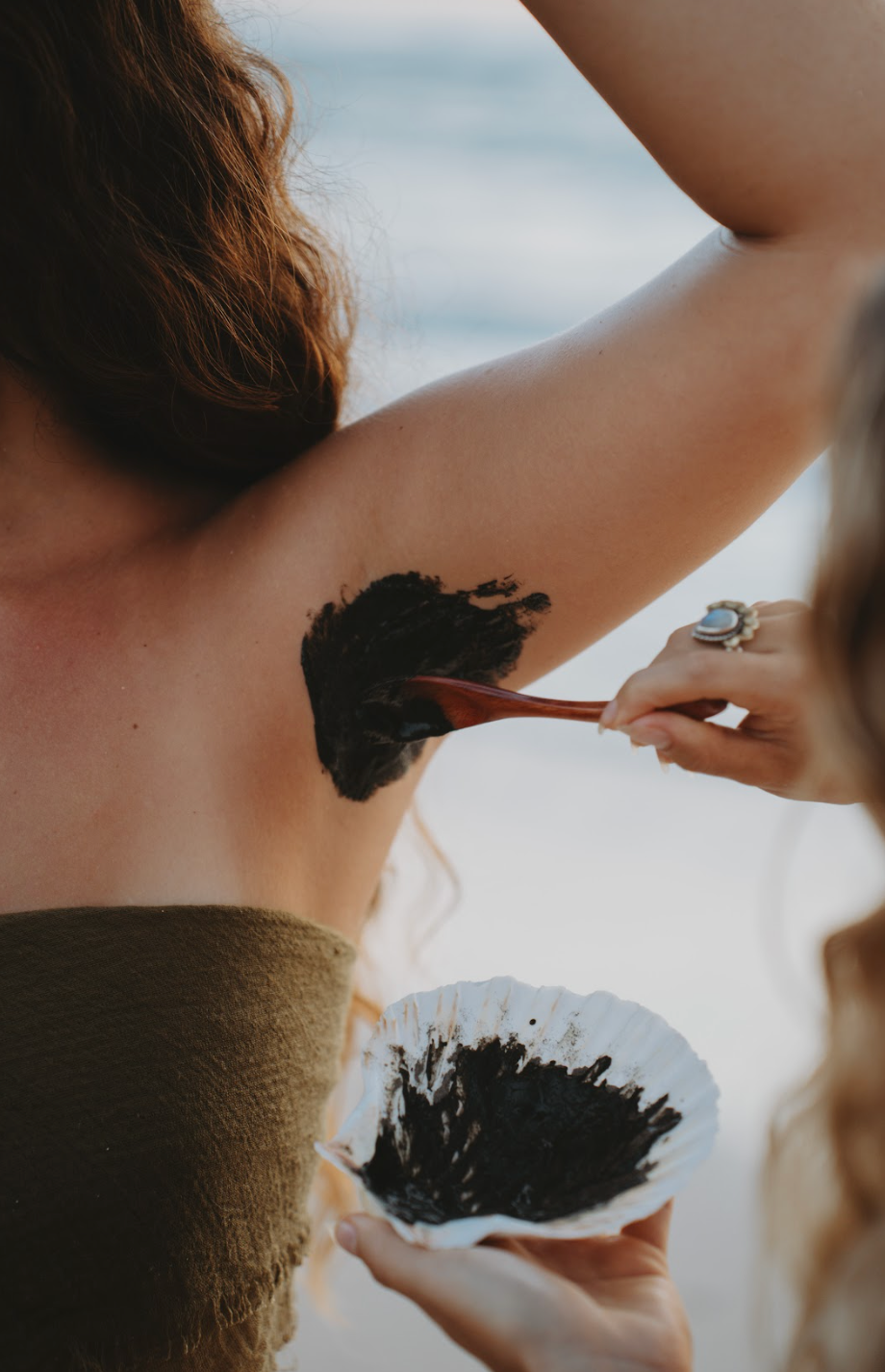 Applying Underarm Detox Mask clay paste to underarm area to remove heavy metals, rebalance microbiome, and reduce irritation naturally
