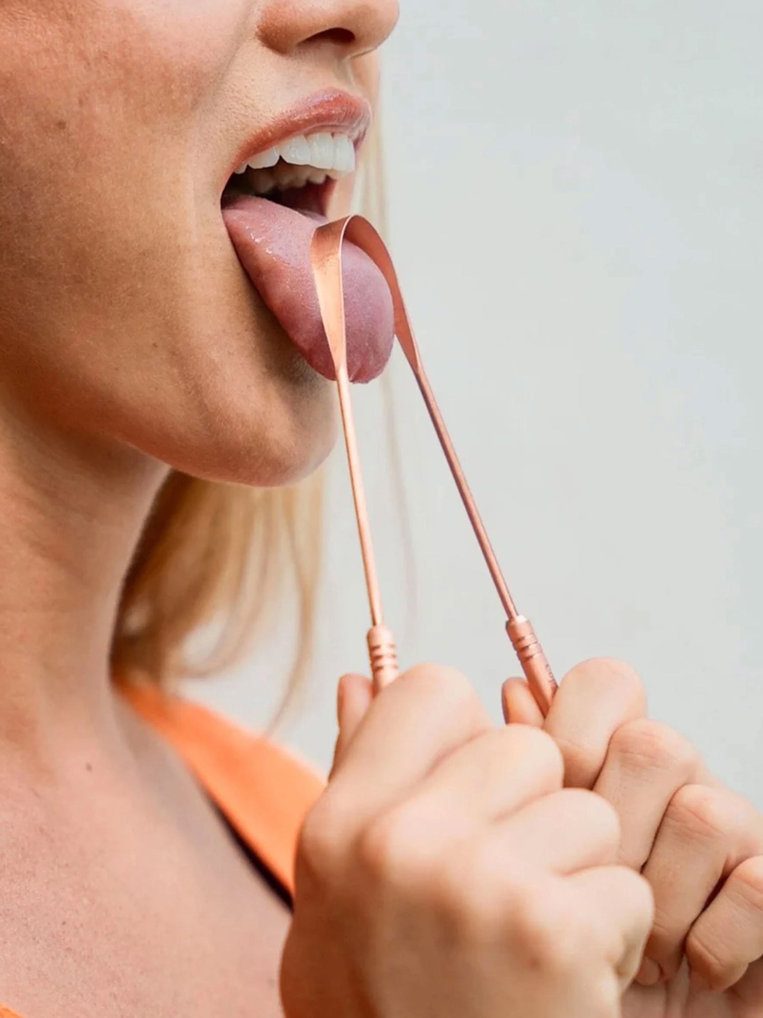 Using a copper tongue scraper as part of a morning Ayurvedic oral hygiene ritual to support fresh breath and digestion